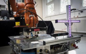 Kooperation intelligenter Maschinen: Der Robotergreifer übergibt ein Werkstück an eine bewegliche Plattform, die es zum nächsten Arbeitsschritt fährt. (Foto: Irina Westermann)