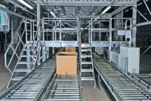 Fahrbare und höhenverstellbare Arbeitsplattform mit Treppenaufgang an einer Sortiermaschine