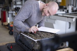 Andreas Leitner, Inspektor der akkredierten Inspektionsstelle, begutachtet die Oberfläche eines beschädigten Bauteils.